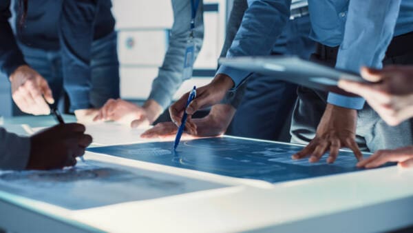 Scientists And Developers Gathered Around Illuminated Conference Table